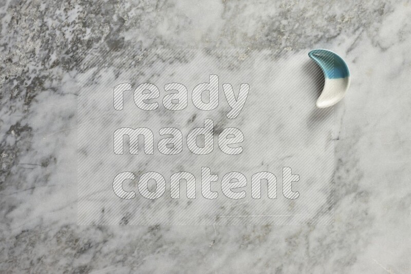 A pottery crescent plate on grey marble background