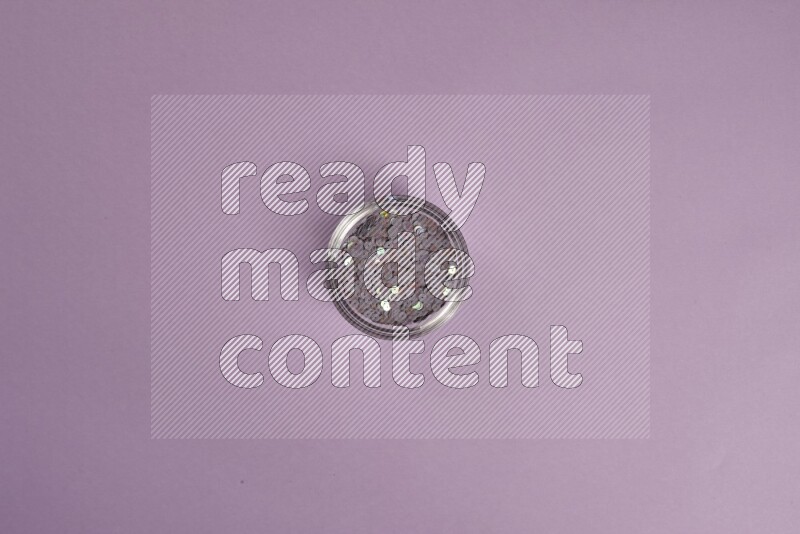 A purple collection of sewing and tailoring tools arranged on a purple background