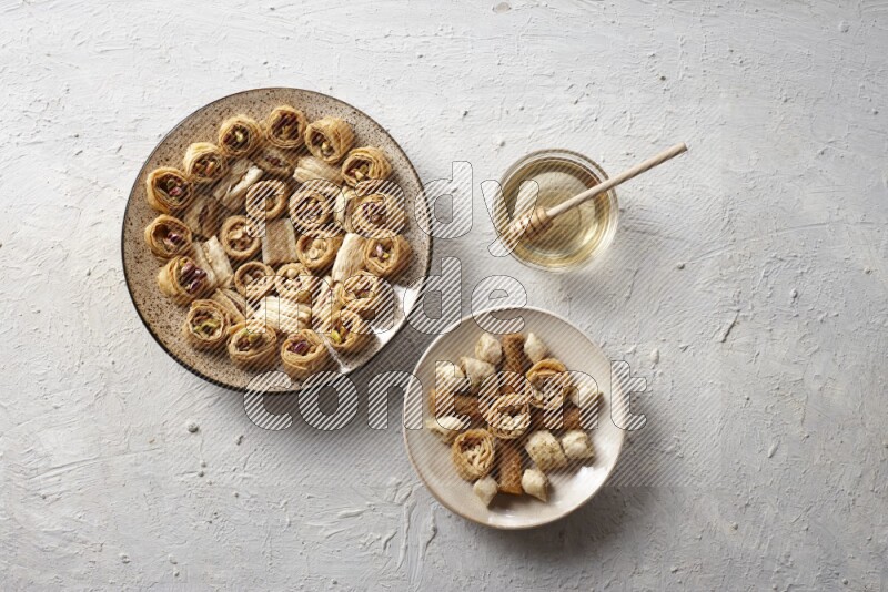 Oriental sweets in pottery plates with honey in a light setup