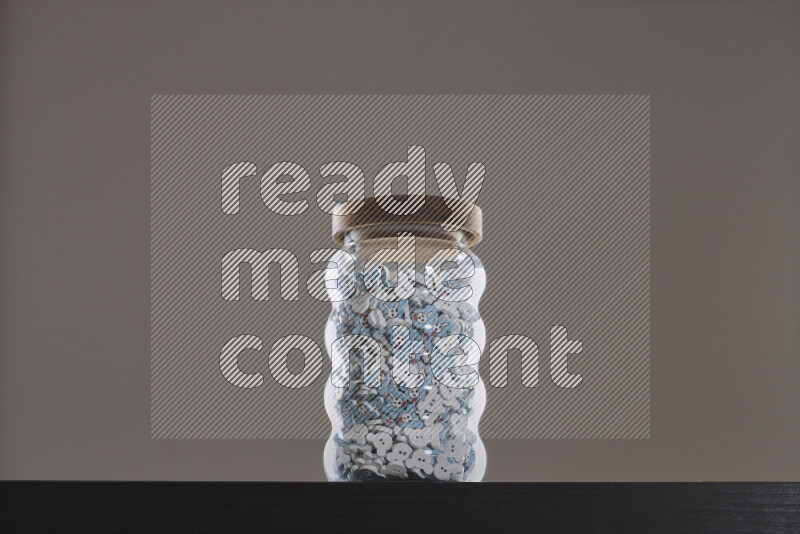 Buttons in a glass jar on black background