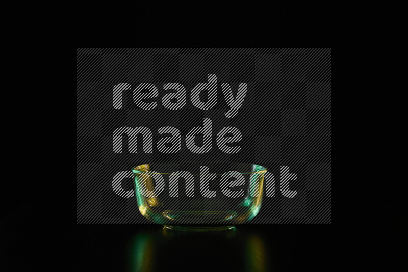 Glassware with rim light in green and yellow against black background
