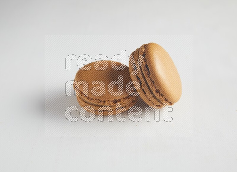 45º Shot of two Brown Maple Taffy macarons on white background