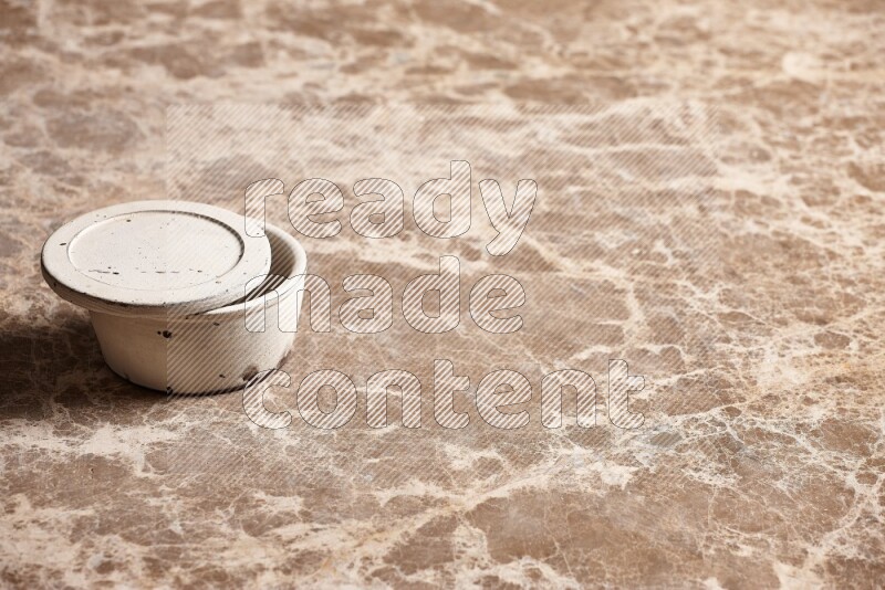 A white pottery bowl on beige marble background