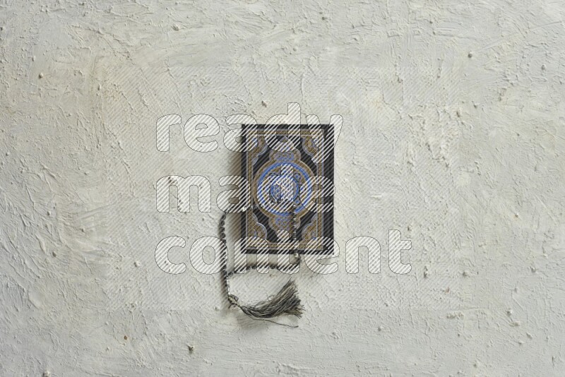 Quran with a prayer beads on white background