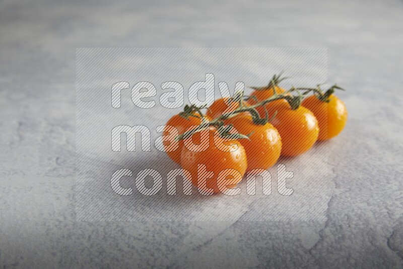 Orange cherry tomato vein on a light grey textured background 45 degree