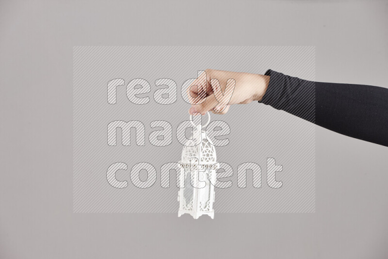 امرأة ترتدي عباءة سوداء تحمل فوانيس رمضانية مختلفة في أوضاع متعددة