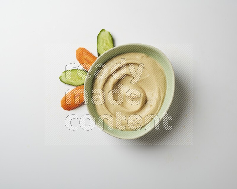 plain Hummus in a green plate on a white background