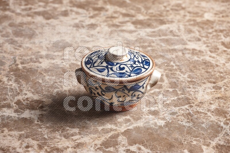 A decorative pottery bowl on beige marble background