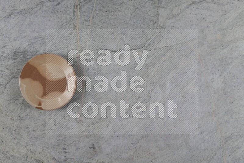 A multicolored pottery plate on grey marble background