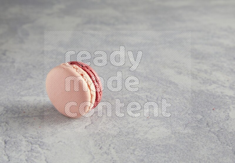 45º Shot of Pink Litchi Raspberry macaron on white  marble background