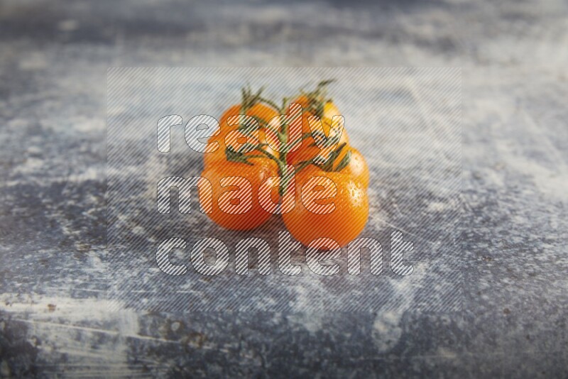 Orange cherry tomato vein on a textured rusty blue background 45 degree