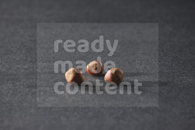 3 hazelnuts on a black background in different angles