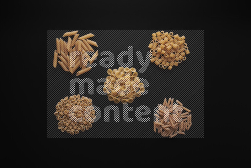 Different pasta types in bunches on black background