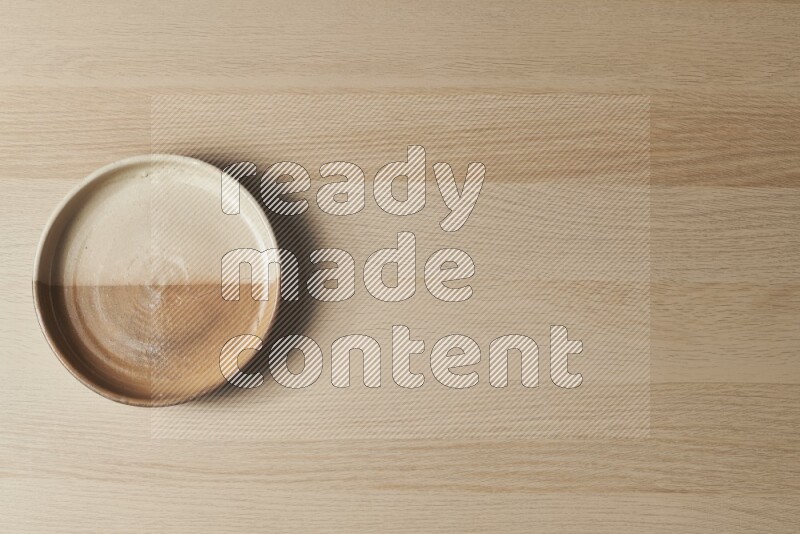 A multicolored pottery oven plate on light wooden background