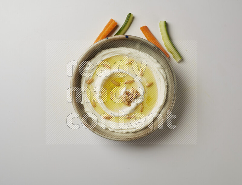 Lebnah garnished with pine nuts in a grey pottery plate on a white background