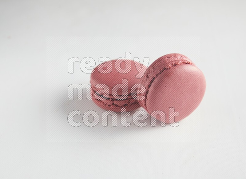 45º Shot of two Pink Raspberry macarons on white background