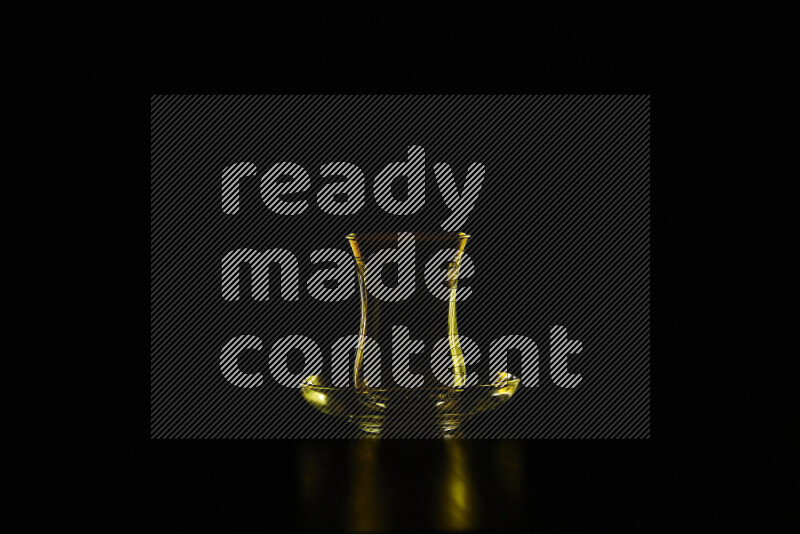 Glassware with rim light in yellow against black background