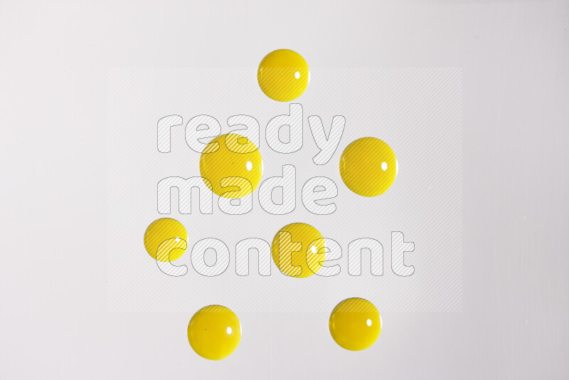 Close-ups of abstract yellow paint droplets on white background