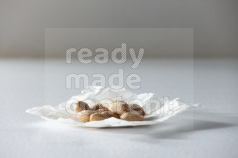 Almonds on a crumpled piece of paper on a white background in different angles