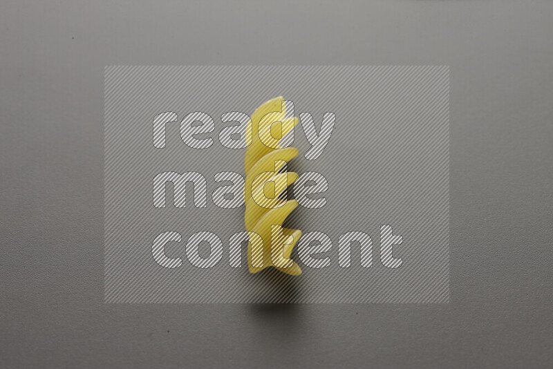 Fusilli pasta on grey background