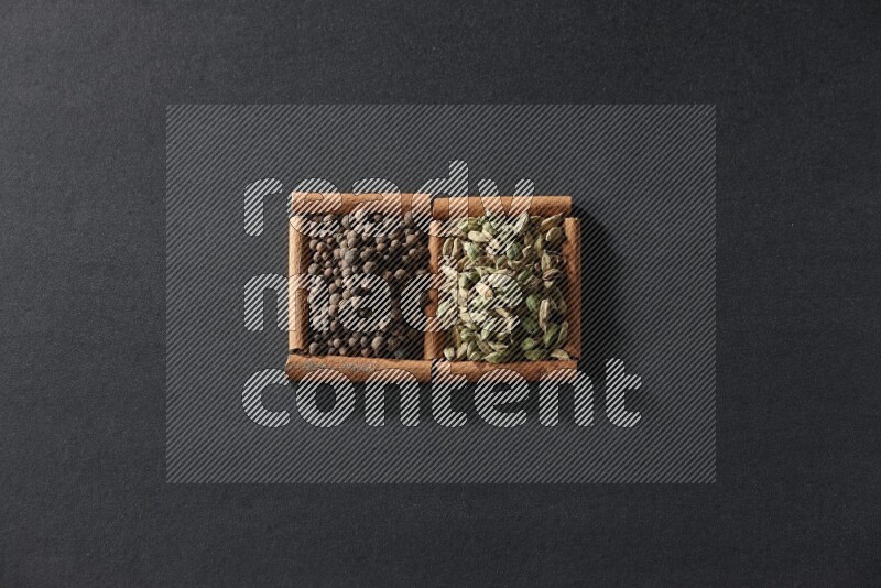 2 squares of cinnamon sticks full of allspice and cardamom on black flooring