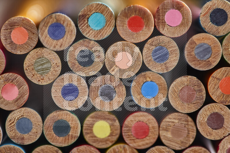 A close-up of the tips of colored pencils arranged in a bundle on white background