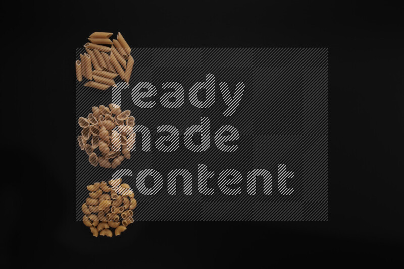 Different pasta types in 3 bunches on black background