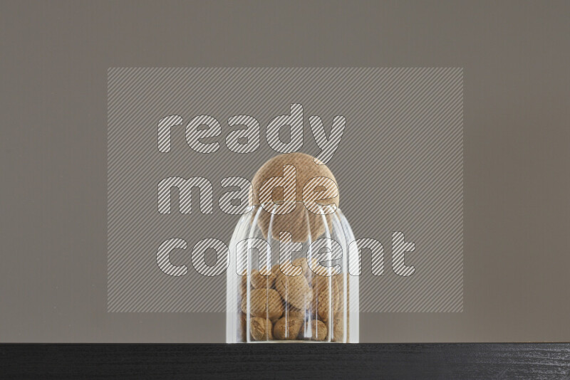 Almonds in a glass jar on black background