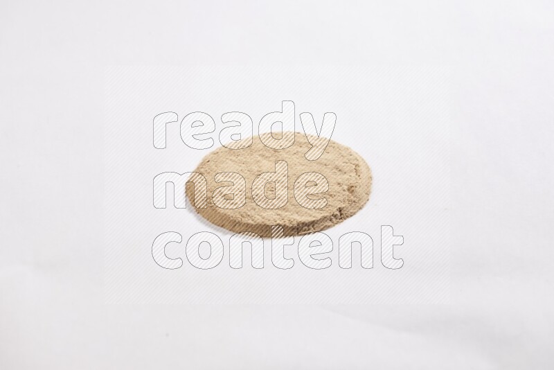 كومة من بودرة الثوم في شكل دائري علي خلفية بيضاء