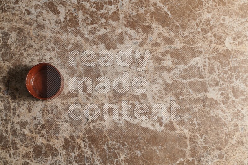 Top View Shot Of A Brown Pottery bowl On beige Marble Flooring