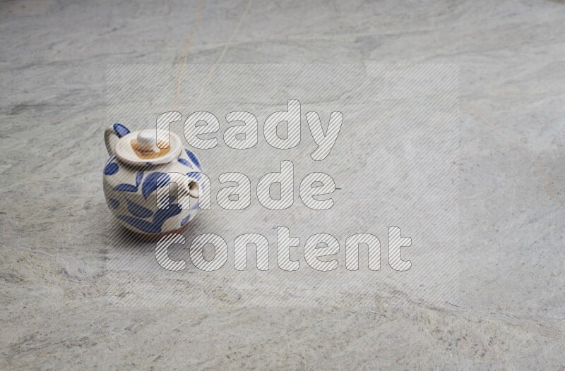 A pottery teapot on grey marble background