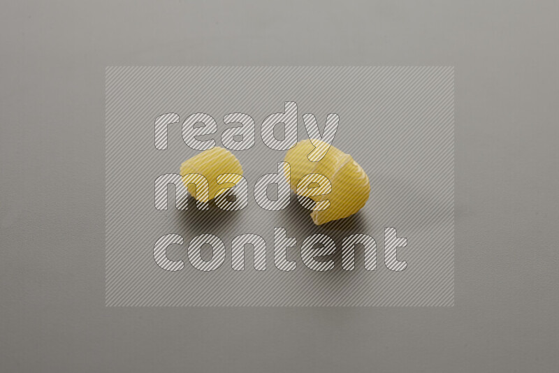 Big rings pasta with other types of pasta on grey background