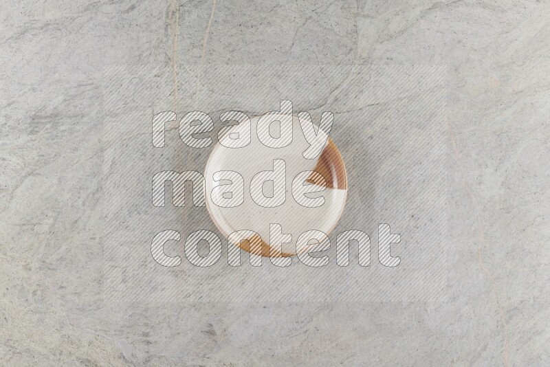 A decorative pottery plate on grey marble background
