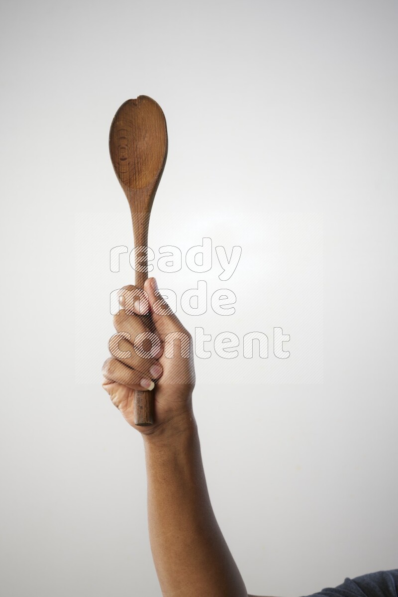 Male Hand Holding Wooden spoon on white background