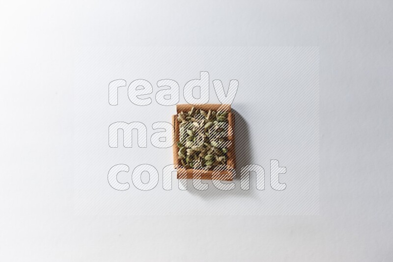 A single square of cinnamon sticks full of cardamom on white flooring