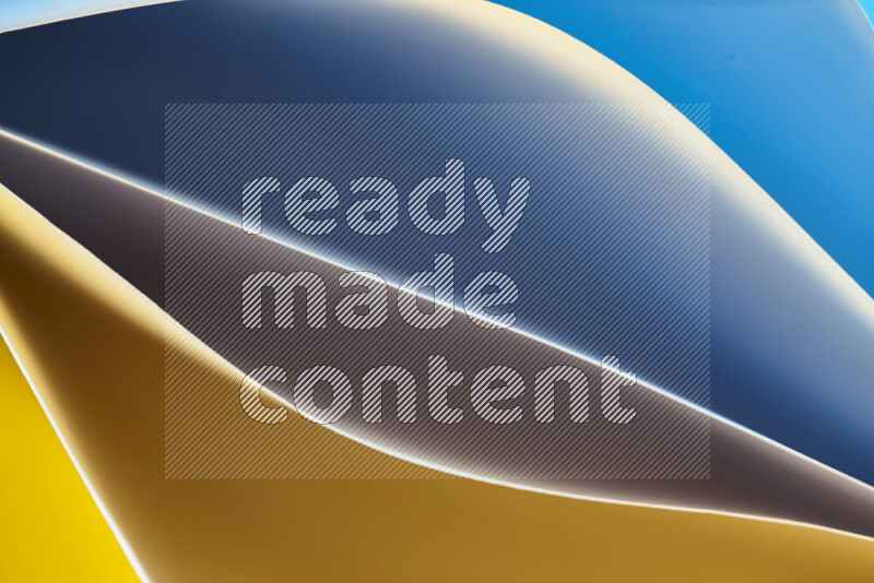 This image showcases an abstract paper art composition with paper curves in blue and yellow gradients created by colored light