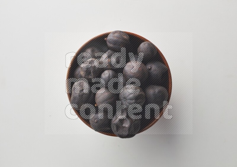 Top-view shot of dried lime (loomi) in a container on white background