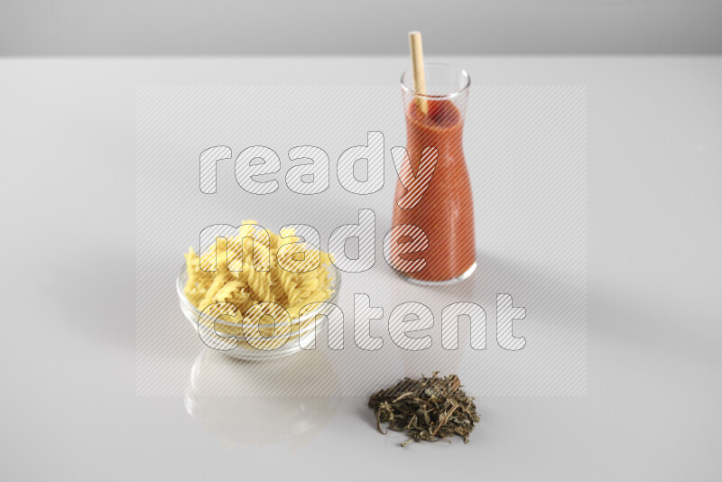 معكرونة مع صلصة طماطم مع مكونات متنوعة من الطماطم والثوم والريحان والفلفل الأحمر والفلفل الأسود والفلفل الأبيض وأوراق الغار والهيل وسنابل القمح على خلفية رمادية