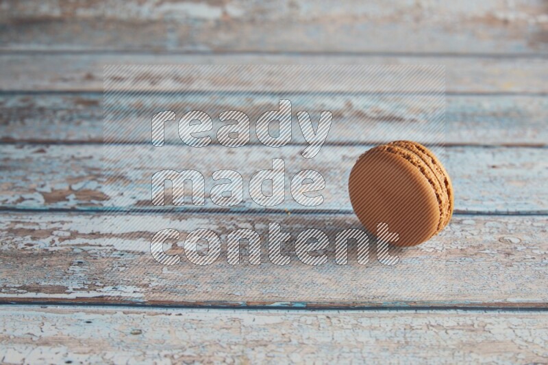 45º Shot of Brown Maple Taffy macaron on light blue wooden background