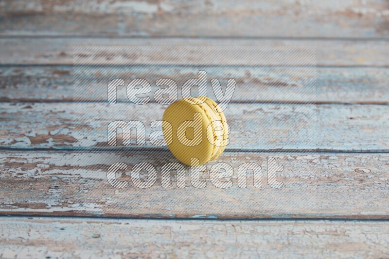 45º Shot of Yellow Lime macaron on light blue wooden background