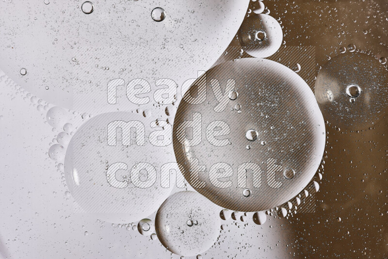 Close-ups of abstract oil bubbles on water surface in shades of white and brown