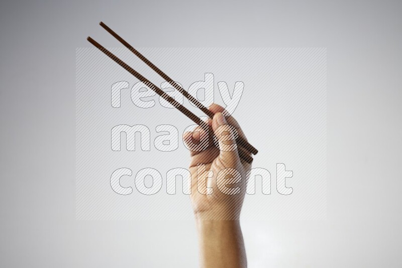 Male Hand Holding Chop Stick on white background