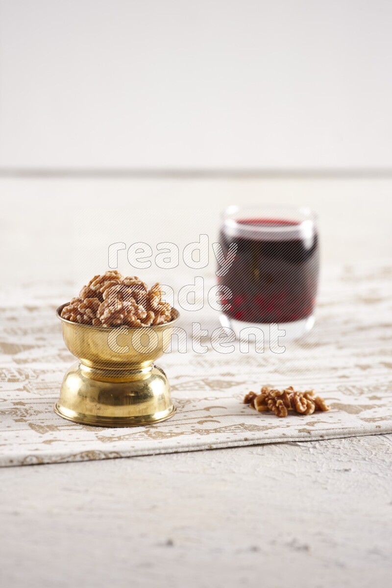 Nuts in a metal bowl with hibiscus in a light setup