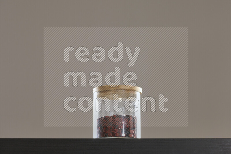 Sequins in a glass jar on black background