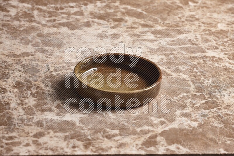 A multicolored pottery oven plate on beige marble background