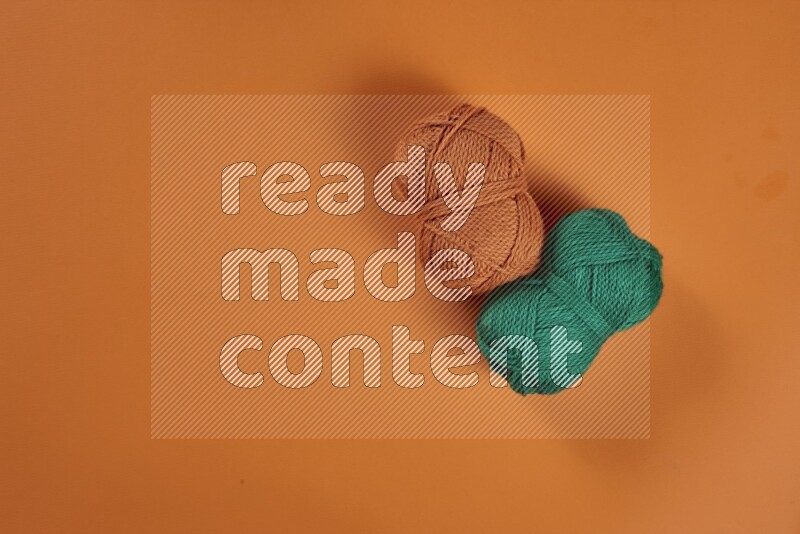 A green and orange collection of sewing and tailoring tools arranged on a orange background