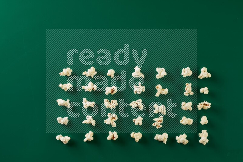 Popcorn flakes on a green background in a top view shot