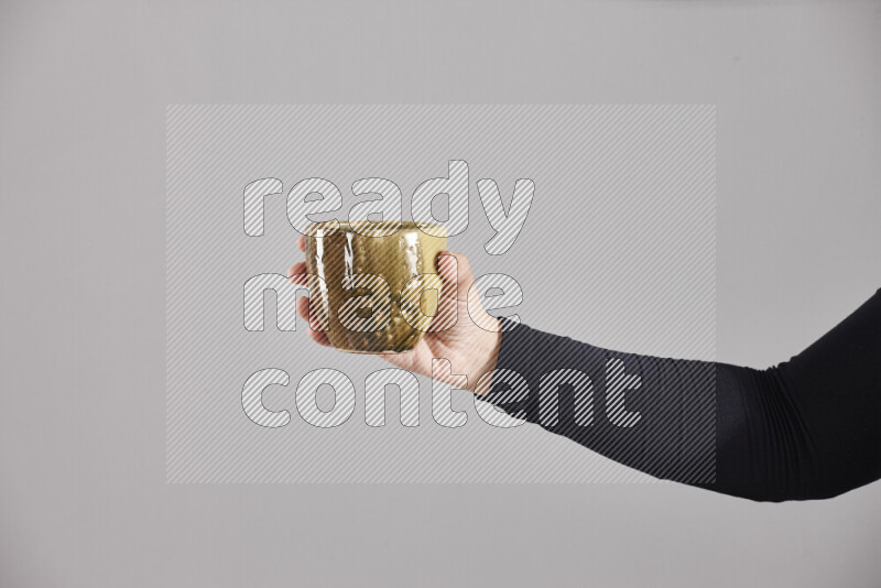 A woman in black abaya holding different pottery essentials in different positions