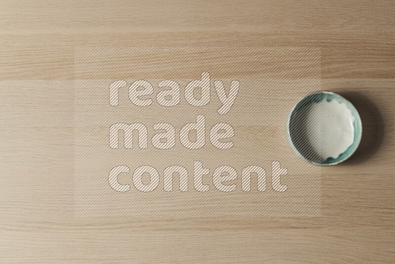 وعاء فخاري متعدد الألوان على خلفية خشبية فاتحة