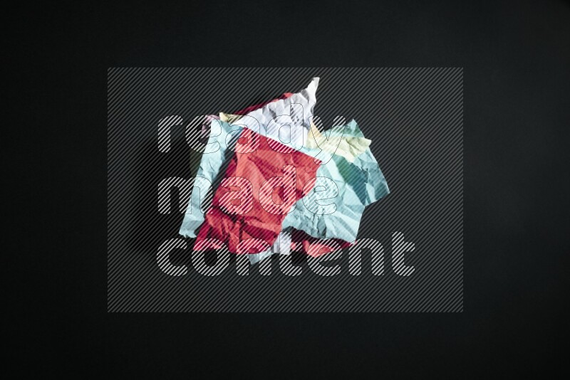 Crumpled multicolored paper on black background